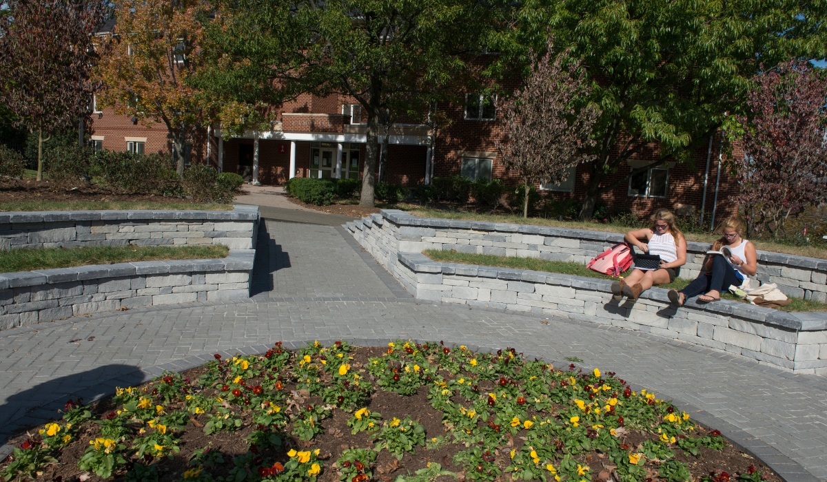 Centennial Village with students and flowers in front