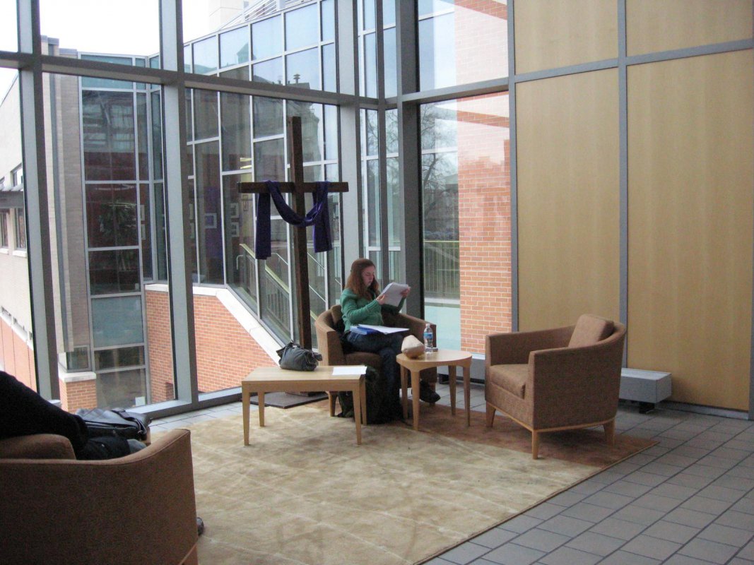 Pryzbyla Atrium with student sitting in chair and a cross placed nearby